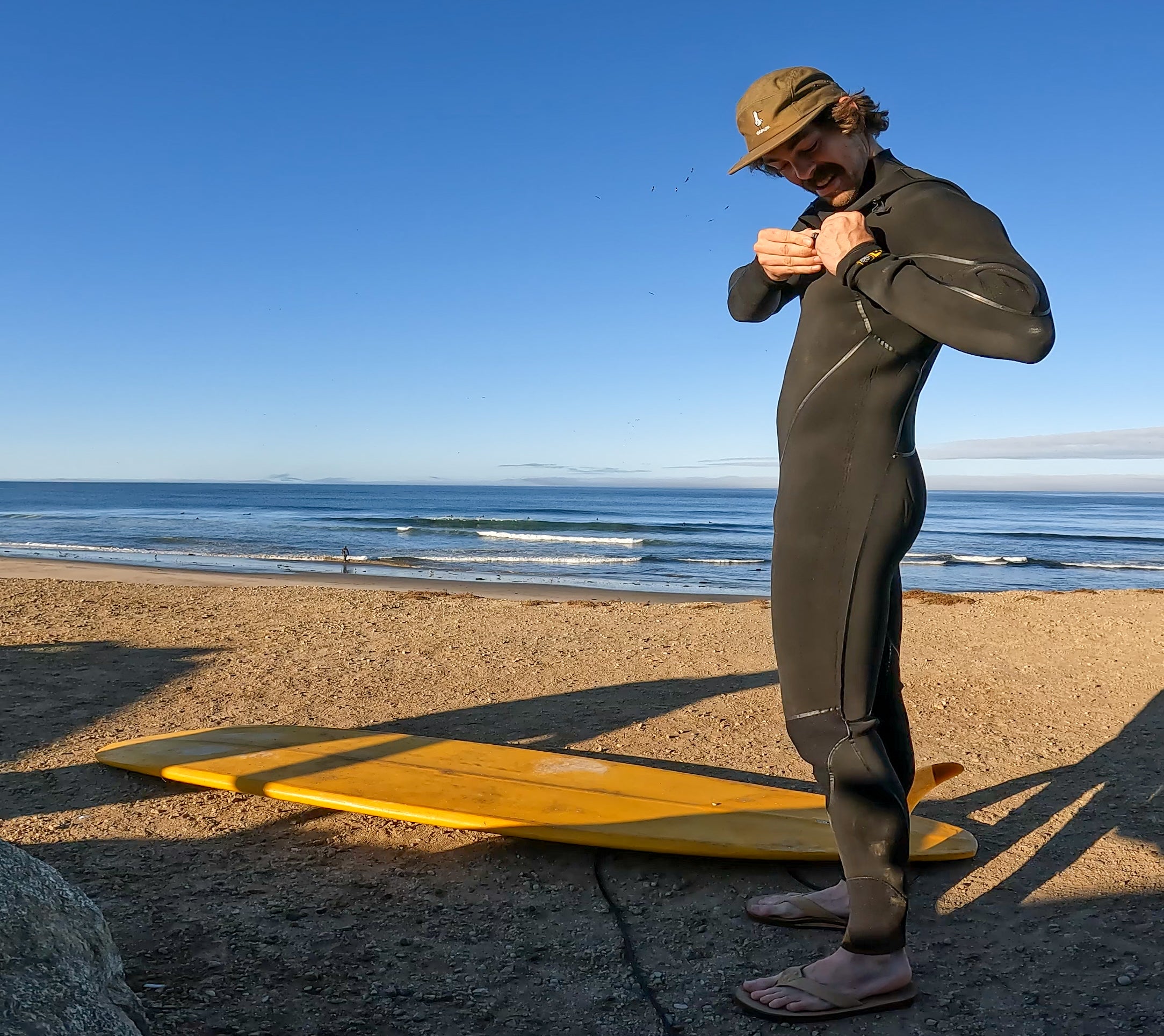 santa cruz surfer with yellow surfboard and 5 panel hat with seagull and sqawk